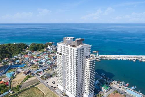 an aerial view of a tall white building next to the ocean at Gangneung The Gangneung Ocean Stay Part4 in Gangneung