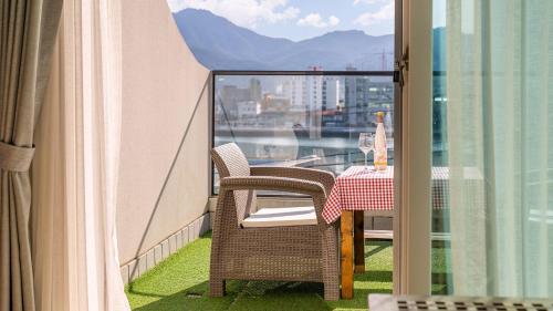 a balcony with a table and chairs and a view at Tongyeong Pension Present Pension in Tongyeong