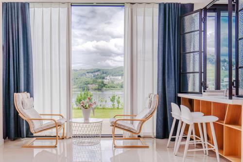 a living room with chairs and a large window at Gapyeong Pension The Square 24 Spa Pension in Gapyeong