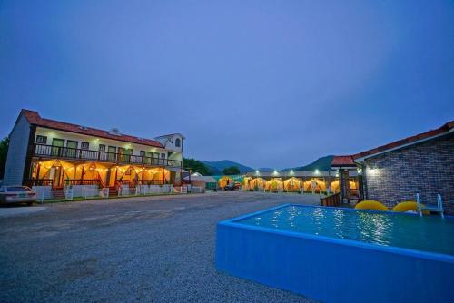 a resort with a pool in front of a building at Anmyeondo Sea Garden Pension Bada-dong Pet Friendly in Taean