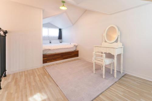 a bedroom with a dressing table and a mirror at Samcheok Dain Spa Pension in Samcheok