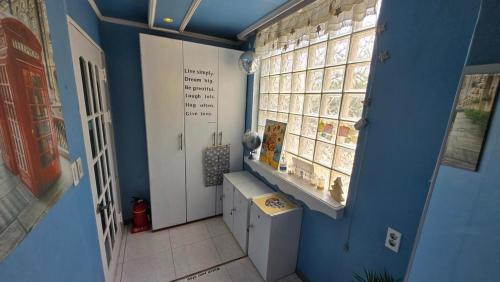 a bathroom with a blue wall and a window at Daegu Glens Guesthouse in Daegu