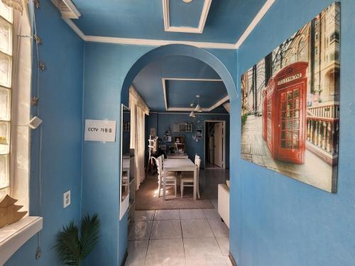 a room with a blue wall with an archway at Daegu Glens Guesthouse in Daegu