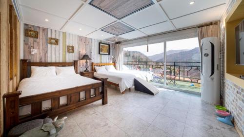 a bedroom with two beds and a balcony at Gaboja Private Pet Pool Villa in Gapyeong