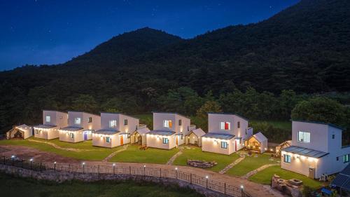 a row of houses on a field at night at Gyeongju Gamseong The Glamping Pool Villa in Gyeongju