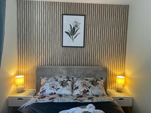 a bedroom with a bed with two lamps and a picture at Tenno Apartment 3 in Kudjape