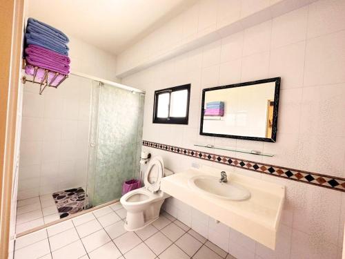 ein Badezimmer mit Toilette, Waschbecken und Spiegel in der Unterkunft 樂點民宿 in Huxi