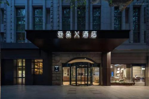 an entrance to a building with a sign on it at Atour X Hotel Shanghai Xujiahui Sports Center in Shanghai