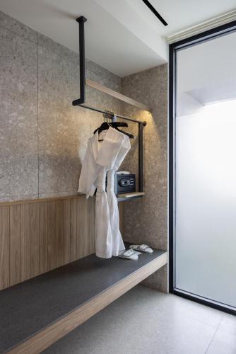a room with a shelf with white robes and shoes at Hotel Santika Premiere Linggarjati - Kuningan in Kuningan