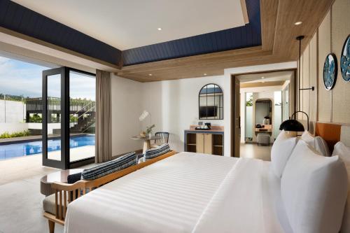 a bedroom with a large white bed and a pool at Hotel Santika Premiere Linggarjati - Kuningan in Kuningan