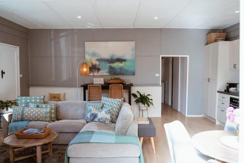 a living room with a couch and a table at Farm Stay & Private Beach at Pear Tree Cottage in Middleton