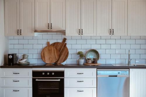 a kitchen with white cabinets and a black oven at Farm Stay & Private Beach at Pear Tree Cottage in Middleton