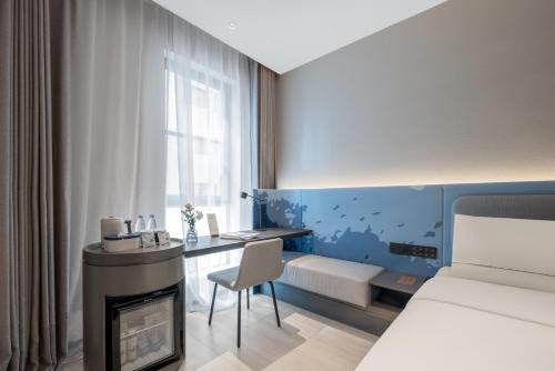 a hotel room with a desk and a bed and a bedroom at Atour Light Hotel Shanghai The Bund East Jinling Road in Shanghai