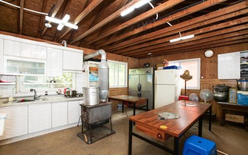 a kitchen with a table and a stove in it at Taean Anmyeondo Sunset Sea Pension in Taean