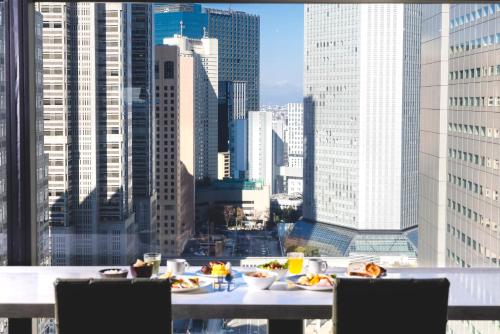 a table with plates of food on top of a city skyline at Shinjuku Washington Hotel Annex in Tokyo