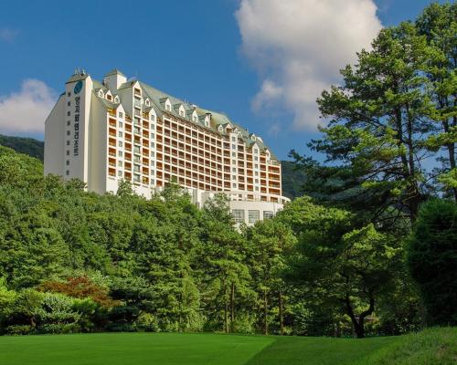 a large white building in the middle of trees at Yangji Pine Resort in Yongin