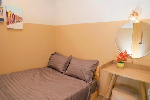 a small bedroom with a bed and a mirror at Gạo's Homestay - The Song in Vung Tau