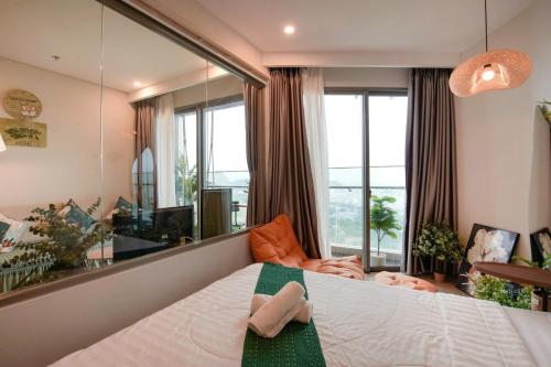a bedroom with a bed and a large window at Gạo's Homestay - The Song in Vung Tau