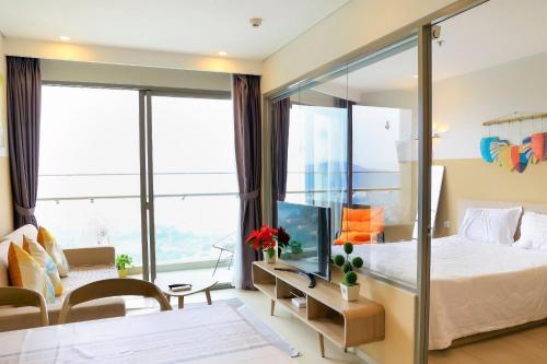 a bedroom with a large bed with a glass wall at Gạo's Homestay - The Song in Vung Tau