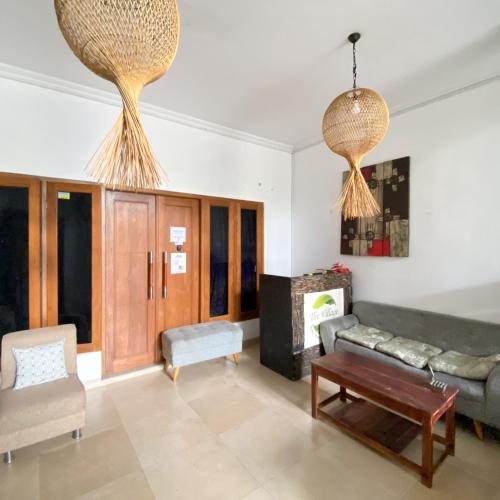 a living room with a couch and a table at Village Homestay Yogyakarta RedPartner in Yogyakarta