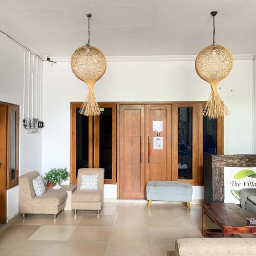 a living room with two chandeliers hanging from the ceiling at Village Homestay Yogyakarta RedPartner in Yogyakarta