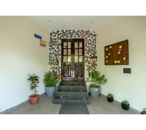 a lobby with stairs and a door with plants at Jungle Ghar in Pachmarhī