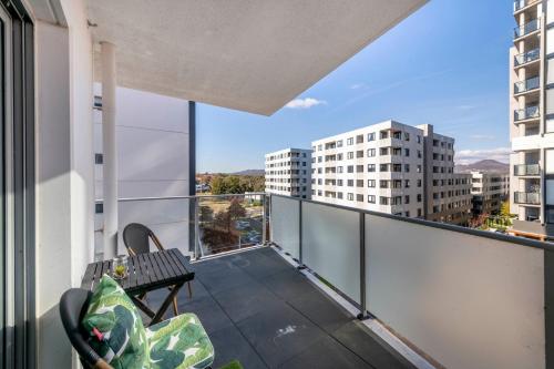 a balcony with a bench and views of buildings at Chic 1-Bedroom Retreat in Greenway in Tuggeranong