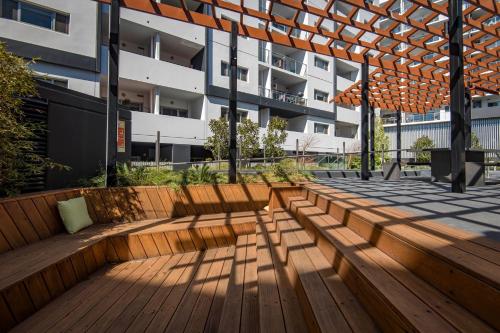 a wooden bench in front of a building at Chic 1-Bedroom Retreat in Greenway in Tuggeranong