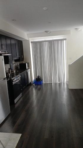 an empty living room with a kitchen and a large window at Home away from home in Cambridge