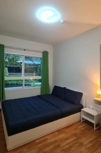 a bedroom with a blue bed and a window at The Condo Hua Hin by yadaphi in Hua Hin