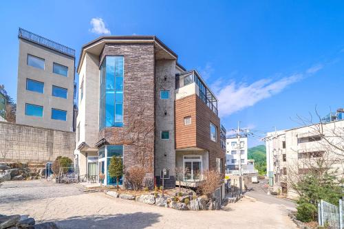 a brick building with a balcony on top of it at Nami Island Koi Pension in Gapyeong