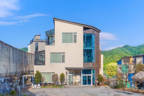 an apartment building with mountains in the background at Nami Island Koi Pension in Gapyeong
