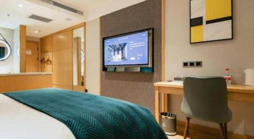 a bedroom with a bed and a desk and a television at Xian Katie Eastman Hotel in Xi'an