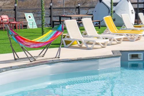 a group of chairs and hammocks next to a pool at Violin Glamping Caravan in Gapyeong