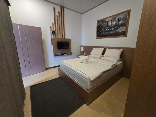 a bedroom with a bed and a flat screen tv at Gili Sal EE in Gili Trawangan