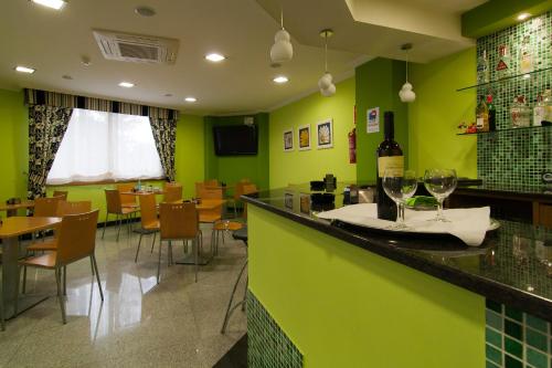 a restaurant with green walls and a bar with wine glasses at Pontus Veteris in Sanxenxo