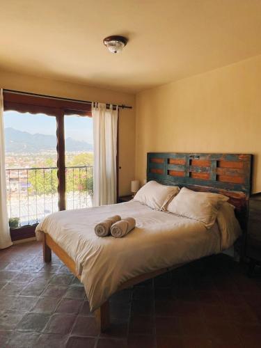 a bedroom with a bed with two towels on it at Casa Ocaso downtown terrace amazing views in San Cristóbal de Las Casas