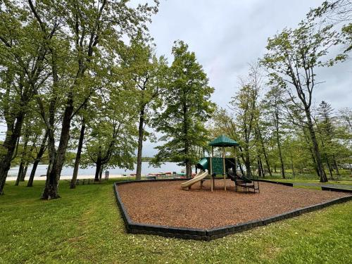 a playground with a slide in a park at Walking Distance to the Beach Cabin with AC in Arrowhead Lake