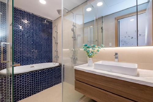 a bathroom with a sink and a glass shower at Aria Vũng Tàu Resort - Căn hộ & Villa in Vung Tau