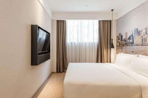 a hotel room with a bed and a television at Atour Hotel Shanghai Hongqiao International Exhibition Beixinjing in Shanghai