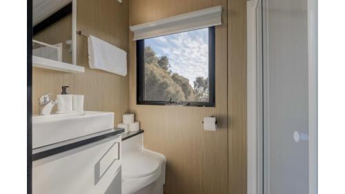 a bathroom with a white toilet and a window at Avon River Homestead by Tiny Away in Beverley