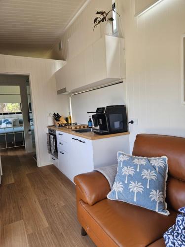 a living room with a couch and a kitchen at Milfarrago Farm Stay in Farnborough