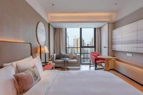a bedroom with a large bed and a living room at Echeng Hotel Nanning Huqiu Metro Station in Nanning