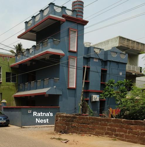 a blue building is under construction on a street at Ratna's Nest Homestay in Puri