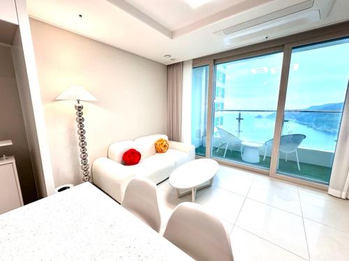 a bedroom with a bed and a couch and a table at THE DECEMBER STAY Busan Songdo Ocean Terrace in Busan