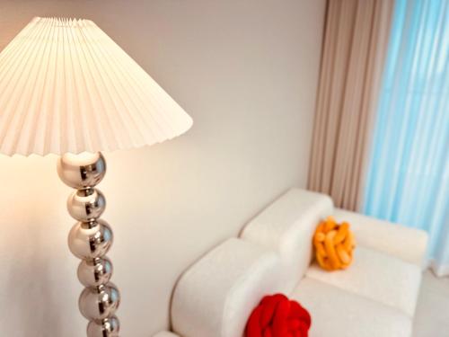 a lamp next to a white couch with a white chair at THE DECEMBER STAY Busan Songdo Ocean Terrace in Busan