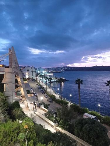 a view of the ocean and a city at night at Pepprina in St. Paul's Bay