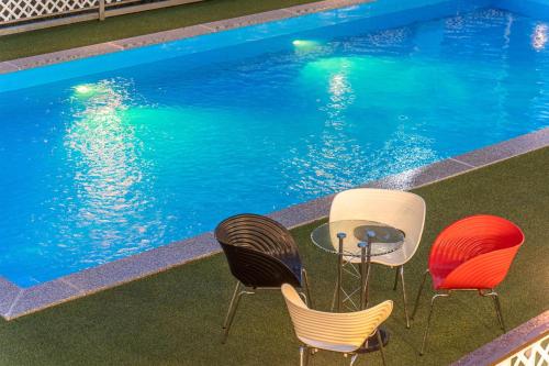 a table and chairs next to a swimming pool at Chuncheon Puppy Day Dog Pension in Chuncheon