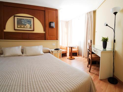 a hotel room with a bed and a desk and a desk at Hotel Pasarela in Seville