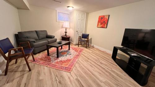 a living room with a couch and a flat screen tv at Downtown-Jackson Park private Budget Friendly Room in Windsor